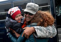 A member the 5th Bomb Wing hugs his family at Minot Air Force Base, N.D., March 4, 2016. Approximately 275 Airmen and four B-52H Stratofortresses returned after a six month deployment to Andersen Air Force Base, Guam. (U.S. Air Force photo by Staff Sgt. Chad Trujillo)