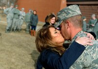 A member from the 5th Bomb Wing kisses his wife at Minot Air Force Base, N.D., March 4, 2016. Approximately 275 Airmen and four B-52H Stratofortresses returned after a six month deployment to Andersen Air Force Base, Guam. (U.S. Air Force photo by Staff Sgt. Chad Trujillo)