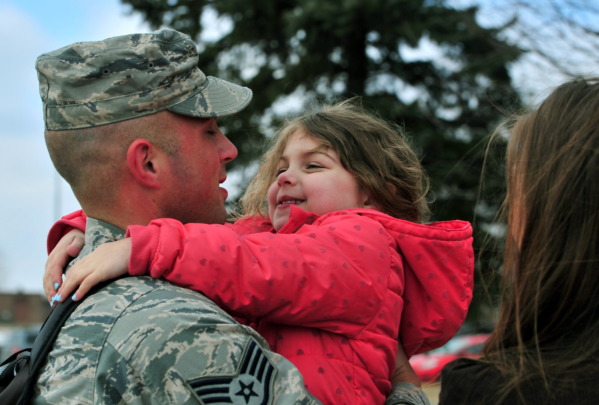 SSgt Tyler Weddle, 5th Bomb Wing, hugs his daughter at Minot Air Force Base, N.D., March 4, 2016. Approximately 275 Airmen and four B-52H Stratofortresses returned after a six month deployment to Andersen Air Force Base, Guam. (U.S. Air Force photo by Staff Sgt. Chad Trujillo)