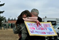 SSgt Tyler Weddle, 5th Bomb Wing, hugs his wife at Minot Air Force Base, N.D., March 4, 2016. Approximately 275 Airmen and four B-52H Stratofortresses returned after a six month deployment to Andersen Air Force Base, Guam. (U.S. Air Force photo by Staff Sgt. Chad Trujillo)