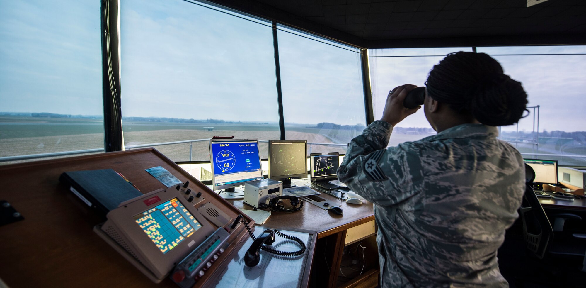 Staff Sgt. Nicole Walker, 424th Air Base Squadron air traffic controller, peers out the Chievres Air Base tower at Chièvres Air Base, Belgium, Feb. 26, 2016. The 424th ABS operates the airfield and runways at Chievres while providing support to the Supreme Allied Commander Europe and Supreme Headquarters Allied Powers Europe (SHAPE), NATO transient aircraft and distinguished visitors. (U.S. Air Force photo/Staff Sgt. Sara Keller)