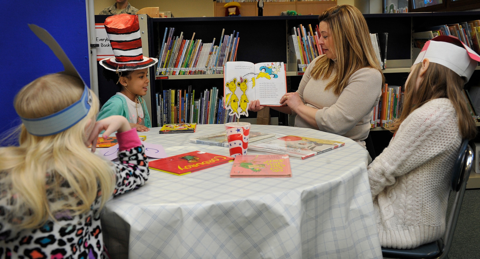 Tracie Barlow, Ramstein Elementary School volunteer, reads to students during Read Across America  week March 2, 2016, at Ramstein Air Base, Germany. The school celebrated by having a theme for each day of the week and had a Dr. Seuss themed ‘café’ where volunteers read to students. (U.S. Air Force photo/Airman 1st Class Larissa Greatwood)  