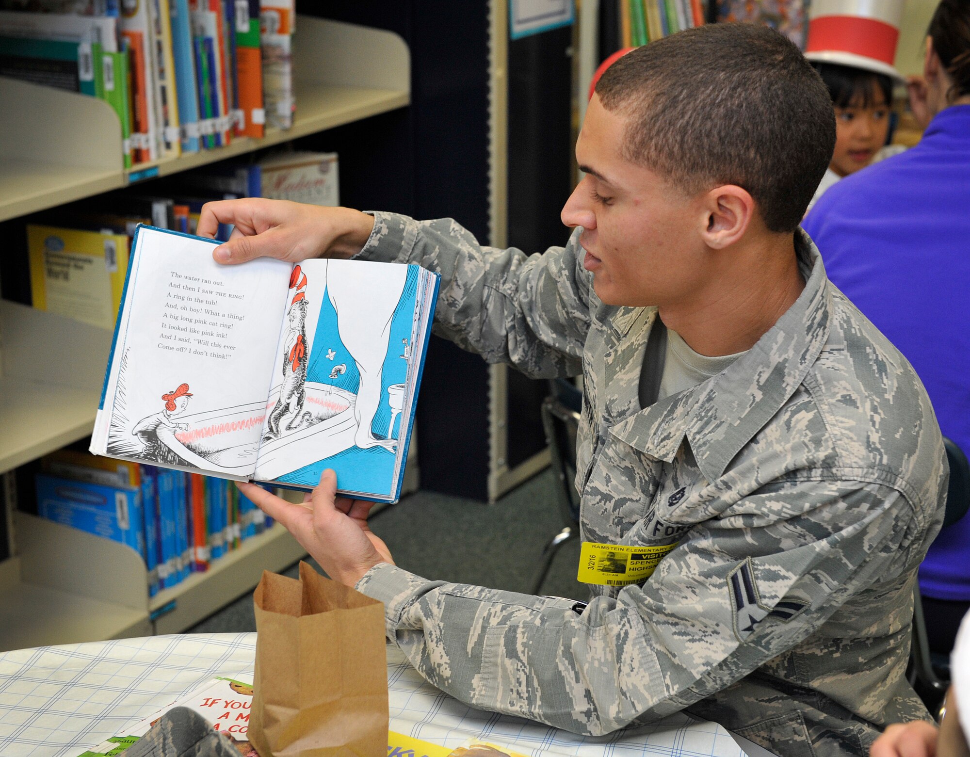 Airman 1st Class Spencer Highsmith, 86th Civil Engineer Squadron firefighter, reads a book to Ramstein Elementary School students during Read Across America week March 2, 2016, at Ramstein Air Base, Germany. Military members, civilians, parents, middle school and high school students volunteered to read books to students. (U.S. Air Force photo/Airman 1st Class Larissa Greatwood)