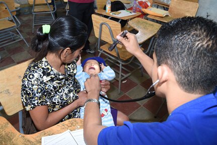 LA PAZ, Honduras - Dr. Oscar Quezada, Honduran medical volunteer, examines a baby girl during a Medical Readiness Training Exercise in La Paz Department, Honduras, March 1, 2016. These medical outreach programs are an opportunity for Hondurans and U.S. Servicemembers to work as a team, providing medical care in local communities. (US. Army photo by Martin Chahin/Released). 