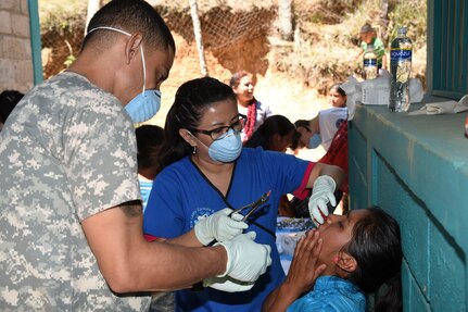 LA PAZ, Honduras - U.S. Army Sgt. William Brown, Joint Task Force-Bravo Medical Element dental provider, and Dr. Zoraida Ramos, Honduran medical volunteer, perform a dental extraction during a Medical Readiness Training Exercise, La Paz Department, Honduras, March 2, 2016. These MEDRETES are an opportunity for U.S. Servicemembers to work with Honduran medical providers in local communities. During the two-day MEDRETE a total of 164 extractions were performed. (U.S. Army photo by Martin Chahin/Released).