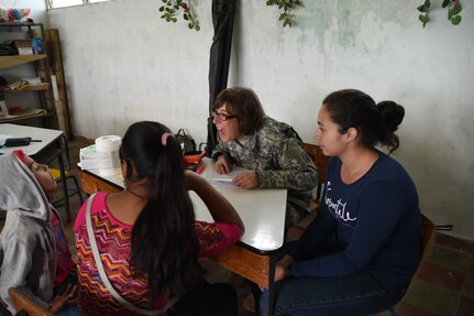 LA PAZ, Honduras – U.S. Army Capt. Michelle Russ, Joint Task Force-Bravo Medical Element medical provider examines a child during a Medical Readiness Training Exercise in La Paz Department, Honduras, March 2, 2016.  Honduran volunteers served as translators, helping U.S. Servicemembers communicate with the patients when needed. A total of 643 Honduran patients were seen during the two-day MEDRETE. (U.S. Army photo by Martin Chahin/Released).