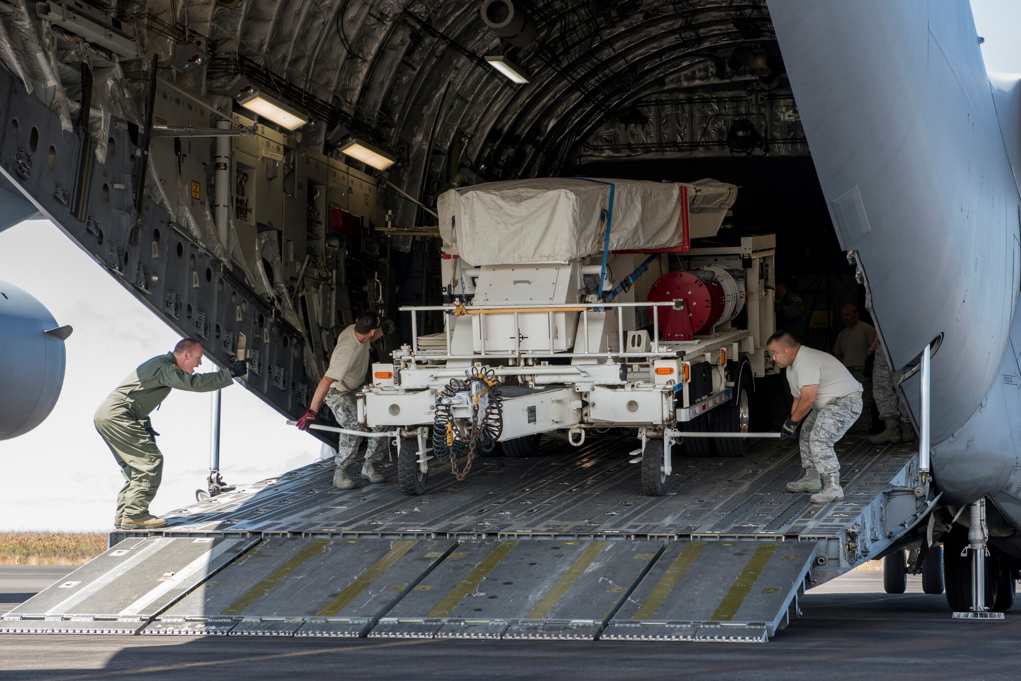 HONOLULU, Hawaii -- Air Guardsmen of the Hawaii Air Guard’s 154th Communications Flight unload equipment under the direction of Tech. Sgt. Chase Carrier, a loadmaster with the Alaska Air Guard’s 249th Airlift Squadron. The local Guardsmen were transported to Kauai on an Alaska Guard C-17 Globemaster III for mobility training. Almost 50 Alaska Air Guardsmen of the 249th Airlift Squadron, 212th Rescue Squadron and 176th Wing support units participated in a search and rescue exercise in the Pacific Air Forces' warmer waters of Honolulu, Hawaii. (U.S. Air National Guard photo by Tech. Sgt. N. Alicia Halla/Released)