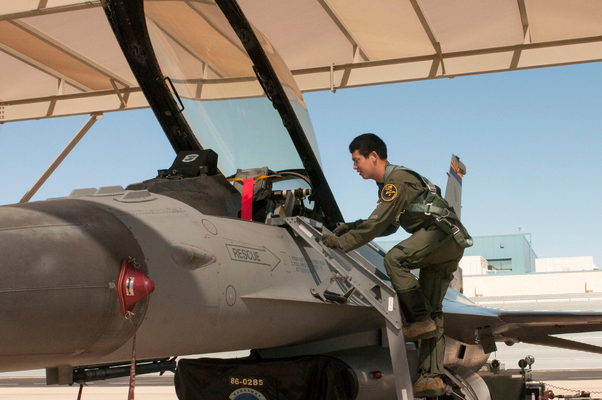 1st Lt. Toshiaki Kawanishi climbs up into the cockpit of an F-16 Fighting Falcon during his pilot training at the Arizona Air National Guard’s 162nd Wing located at Tucson International Airport. “We cannot accomplish the mission with only one country,” said Kawanishi. “This is a good opportunity to learn about other nationalities and personalities, and to be able to apply that to the mission in the future.” (U.S. Air National Guard photo by 2nd Lt. Lacey Roberts)

