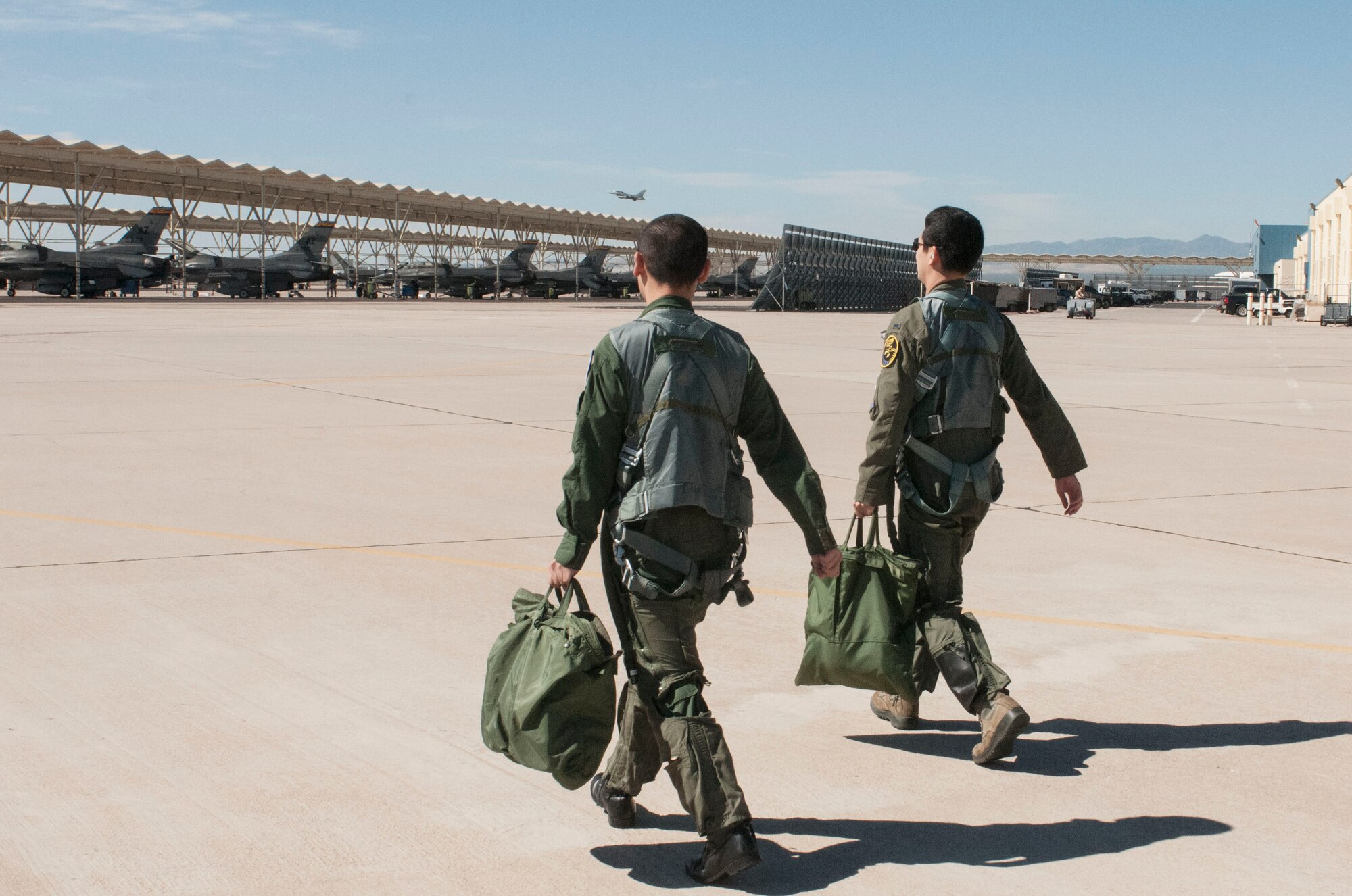 First Lts. Toshiaki Kawanishi and Fumita Sakyu walk out to an F-16 Fighting Falcon at the Arizona Air National Guard’s 162nd Wing located at Tucson International Airport prior to a day of training.  As Japan prepares to mark five years since a massive earthquake triggered a tsunami that devastated its northeast coast, these two Japanese students have completed their F-16 pilot training here. (U.S. Air National Guard photo by 2nd Lt. Lacey Roberts)

