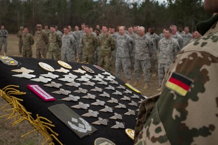 U.S. Army Paratroopers prepare to receive their German jump wings, during Operation Glück ab!, at Fort Gordon, Ga., on March 4th, 2016. Operation Glück ab!, (OGA) is a bi-lateral airborne operation held at Fort Gordon, Ga., March 4, 2016. The purpose of OGA is to foster and nurture German and U.S. relationships, develop interoperability during training, and provide a basis for future operations in training and real world environments. The 982nd Combat Camera Company (Airborne), the 421st Quartermaster Company, and the United States Army Special Operations Command, Flight Company, Dwight D. Eisenhower Army Medical Center are providing support for OGA. (U.S. Army photo by Sgt. Jason A. Young / Released)