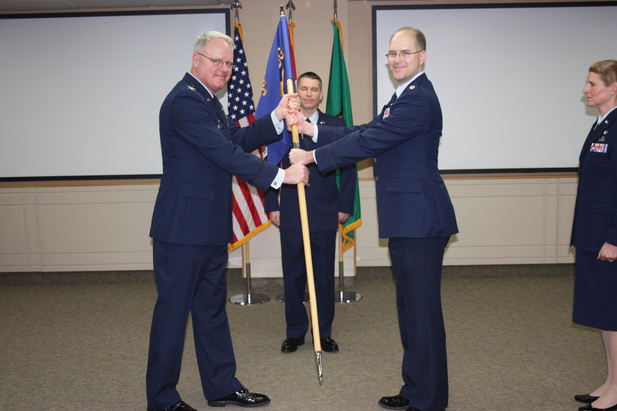 Col. William Krueger, 225th Air Defense Group commander, hands off the guidon to Lt. Col. Brett Bosselmann, 225th Air Defense Squadron commander, during the 225th Air Defense Squadron change of command at the Western Air Defense Sector at Joint Base Lewis-McChord, Wash., Jan. 29, 2016. The 225th ADG is a subordinate unit of the 225th Air Defense Group, which conducts the Western Air Defense Sector's (WADS) mission. WADS is responsible for air sovereignty and counter-air operations over the western United States and directs a variety of assets to defend 2.2 million square miles of land and sea. (U.S. Air National Guard photo by 1st Lt. Colette Muller/Released)