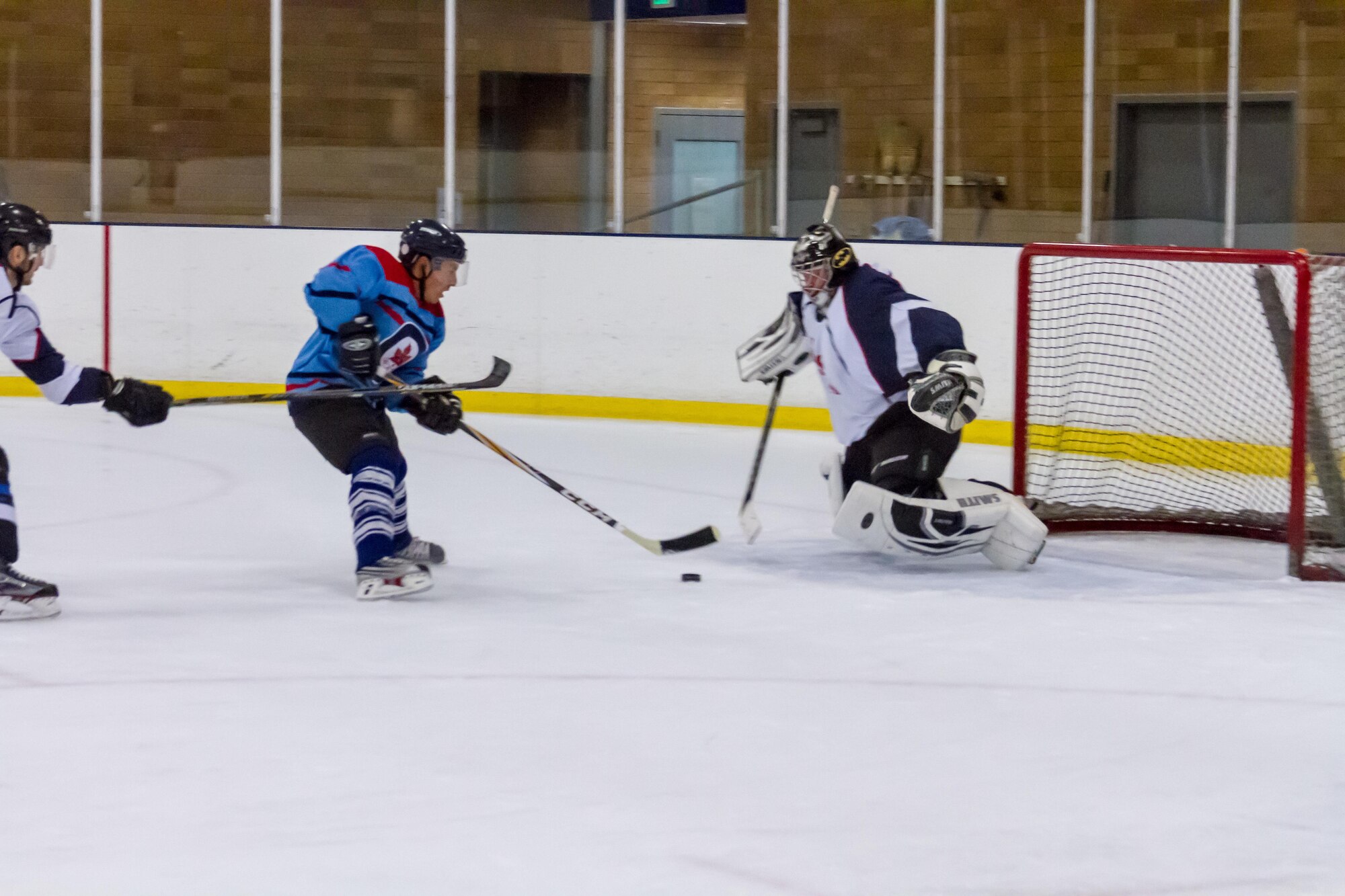 Canada attempts to score against U.S. team hockey goalie, Master Sgt. Ty Henrichsmeger.  Canada won 4-3 in the final seconds of the match. (Courtesy photo by Conrad Neumann III)