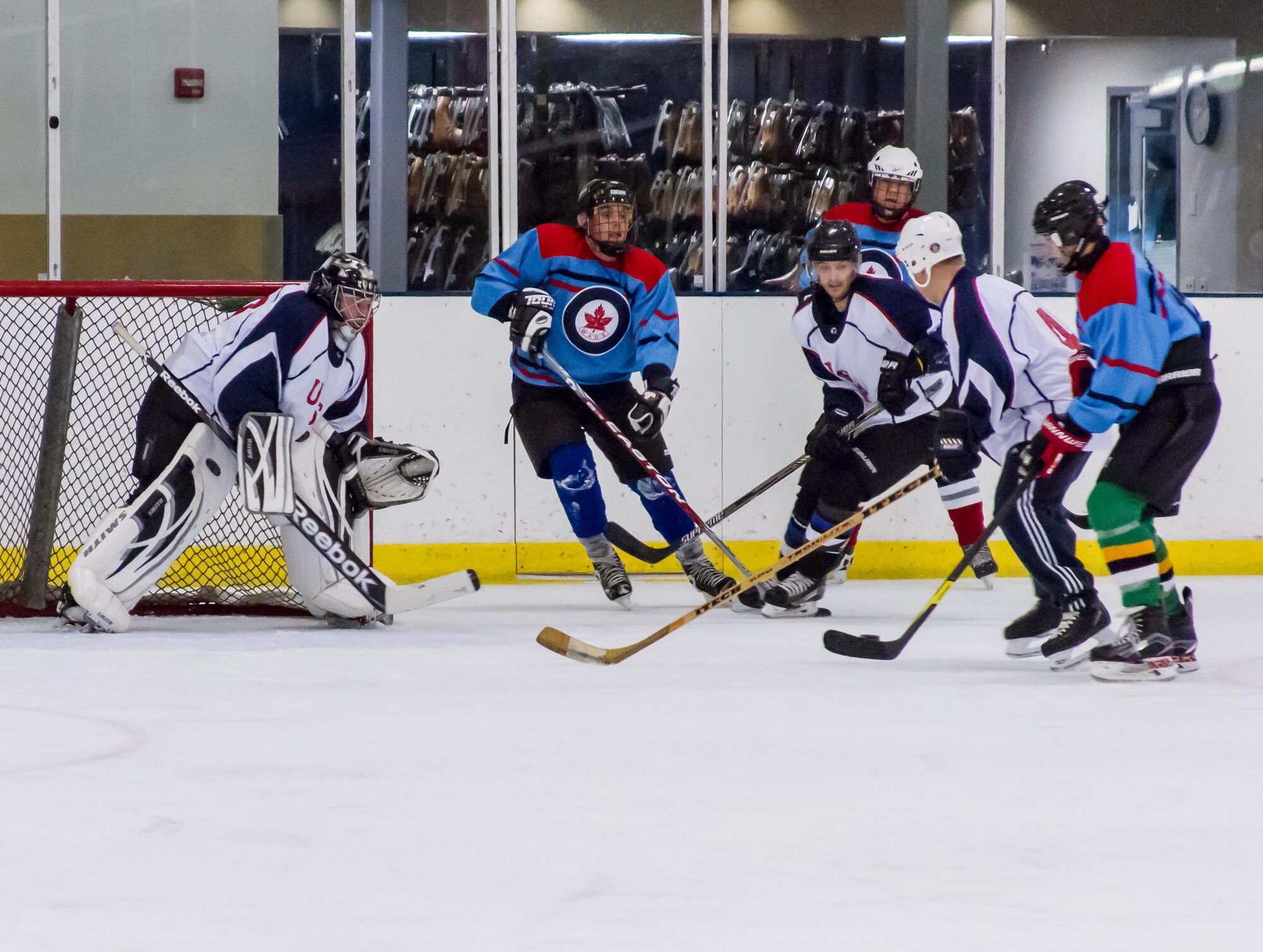 Western Air Defense Sector U.S. team members hold off the Canadian team from scoring with the help of skilled U.S. team goalie, Master Sgt. Ty Henrichsmeger. WADS is responsible for air sovereignty and counter-air operations over the western United States and directs a variety of assets to defend 2.2 million square miles of land and sea.  The event has been a classic team building event for U.S. and Canada, whose airmen work side by side every day. (Courtesy photo by Conrad Neumann III)