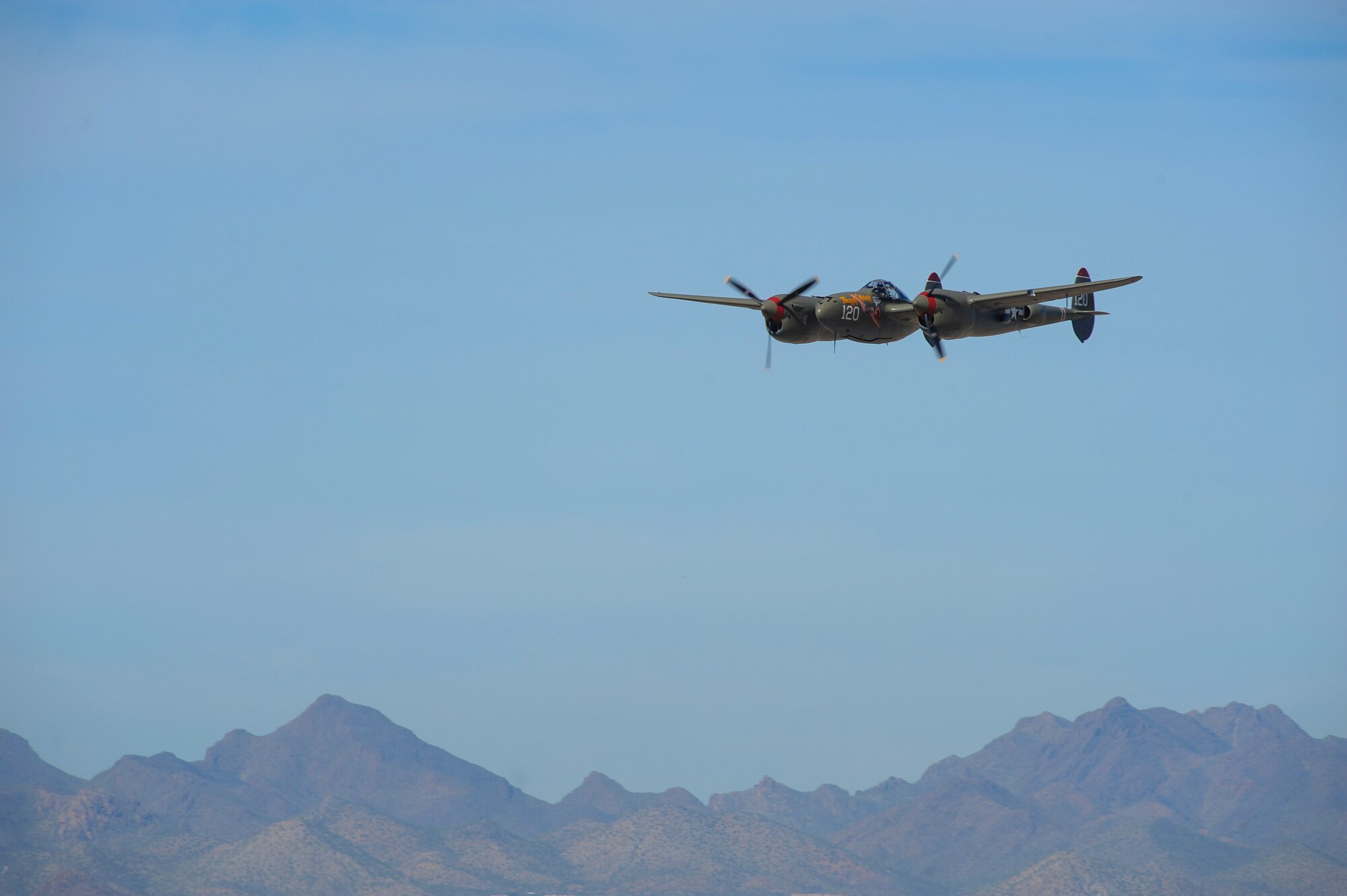 A P-38 Lightning performs a flyover during the 2016 Heritage Flight Training and Certification Course at Davis-Monthan Air Force Base, Ariz., March 5, 2016. The annual aerial demonstration training event has been held at D-M AFB since 2001, the course featured aerial demonstrations from historical and modern fighter aircraft. (U.S. Air Force photo by Airmen 1st Class Ashley N. Steffen/Released)