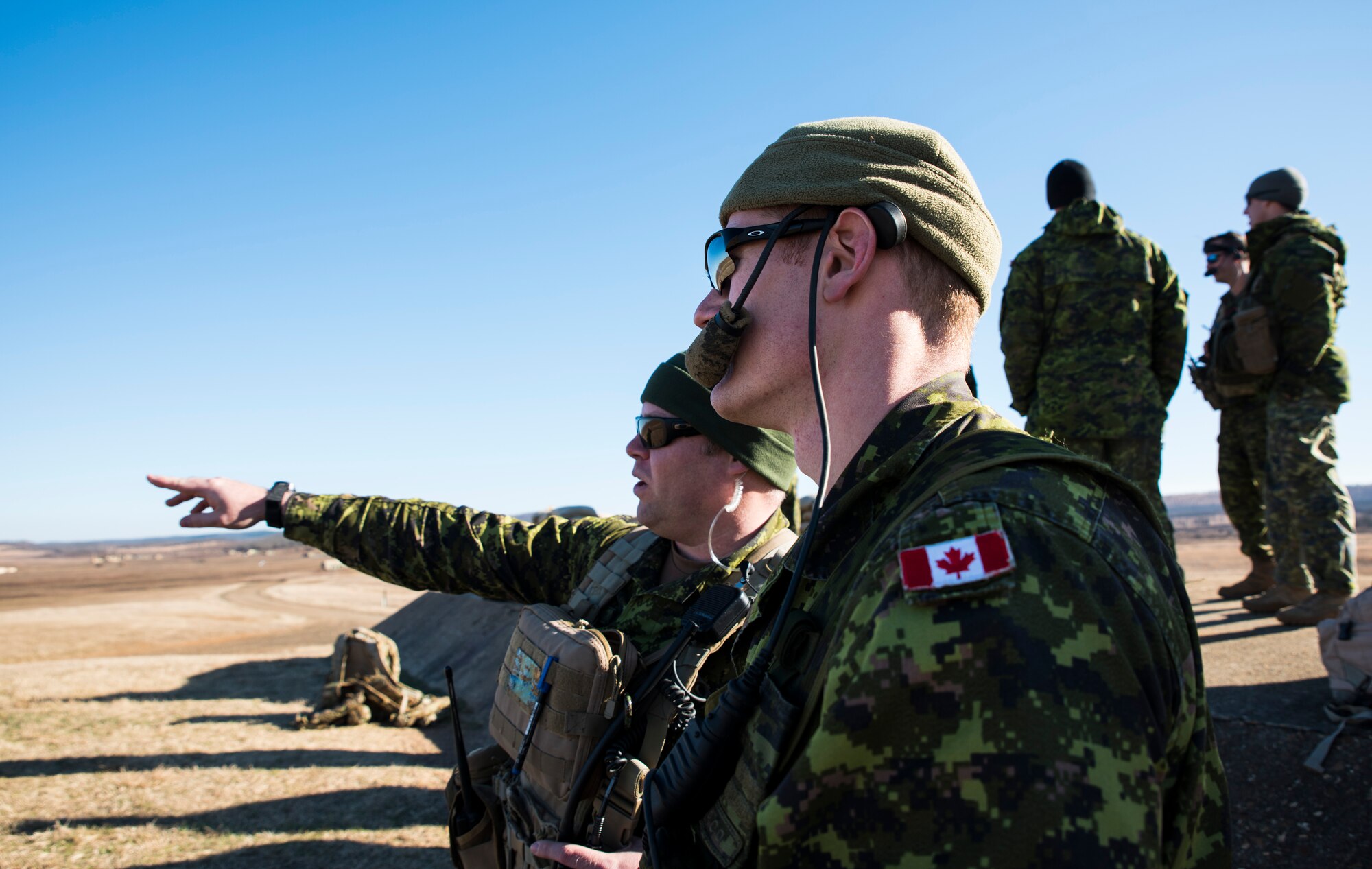 Sgt. Paul Thomas, Y Battery 2nd Regiment Royal Canadian Horse Artillery joint terminal attack controller evaluator, points out a location for Simon Johnson, Y Battery 2RCHA JTAC, to have an allied aircraft simulate an attack Feb. 10, 2016, during training held at Razorback Range, Fort Chaffee Joint Maneuver Training Center, Fort Smith, Ark. Canadian JTACs are required to train abroad at least twice a year and chose to come to Razorback Range to benefit from the wealth of training opportunities provided there. (U.S. Air National Guard photo by Senior Airman Cody Martin/Released)