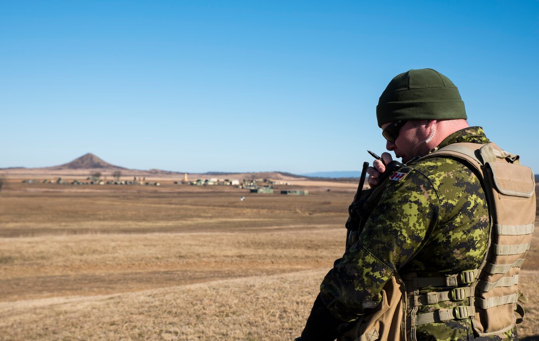 Sgt. Paul Thomas, Y Battery 2nd Regiment Royal Canadian Horse Artillery joint terminal attack controller evaluator, communicates ground information to allied aircraft Feb. 10, 2016, during training held at Razorback Range, Fort Chaffee Joint Maneuver Training Center, Fort Smith, Ark. Canadian JTACs are required to train abroad at least twice a year and chose to come to Razorback Range to benefit from the wealth of training opportunities provided there. (U.S. Air National Guard photo by Senior Airman Cody Martin/Released)