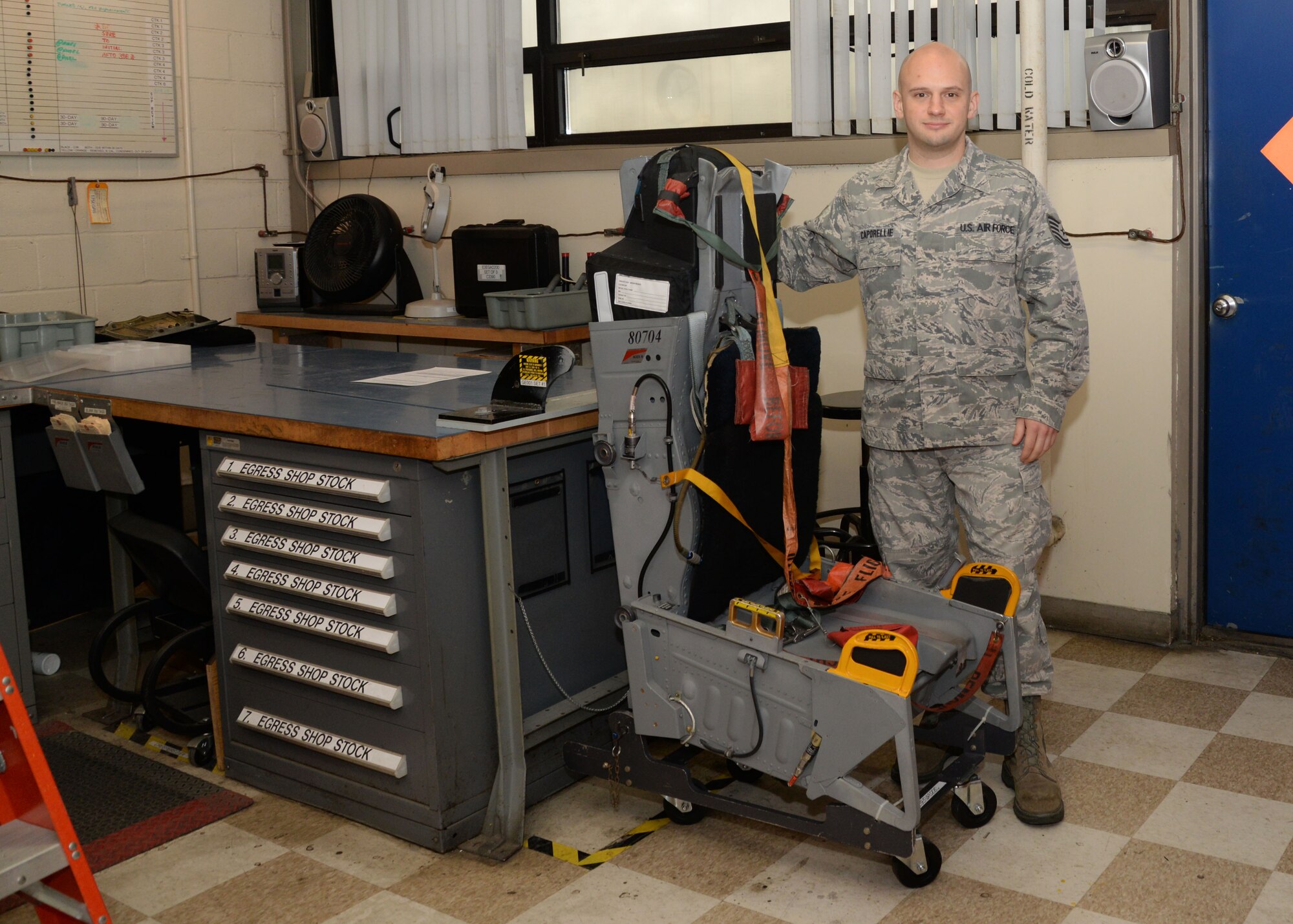 Tech. Sgt. Michael Caporelli, 175th Maintenance Squadron aircrew egress systems specialist stands next to a complete ACES II Ejection Seat at Warfield Air National Guard Base, Middle River, Md. Caporelli is the Maryland Air National Guard March Spotlight Airman. (U.S Air National Guard Photo by Airman 1st Class Enjoli Saunders/RELEASED)