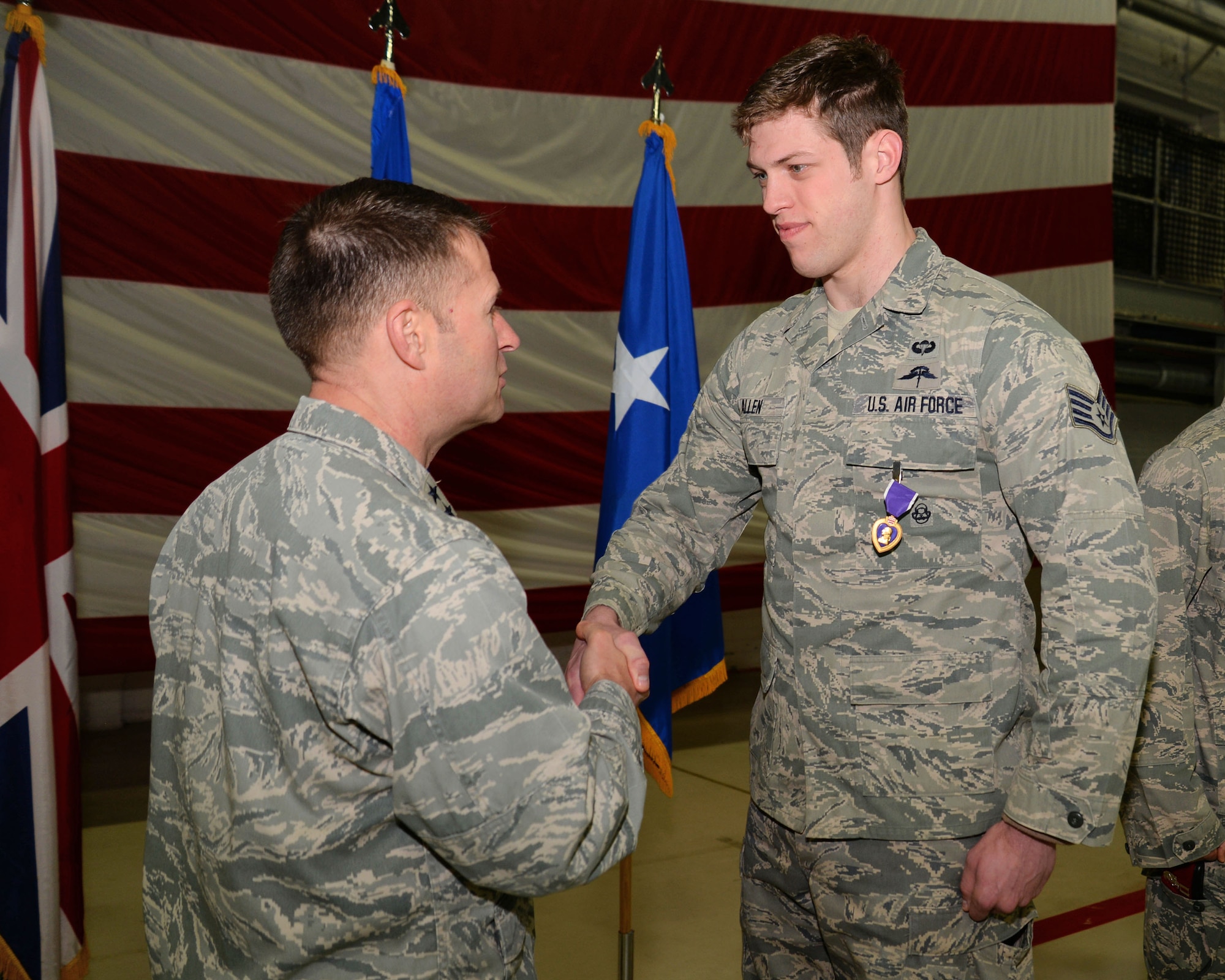 U.S. Air Force Staff Sgt. Cody Allen, 321st Special Tactics Squadron combat controller, shakes the hand of U.S. Air Force Maj. Gen. Gregory Lengyel, Commander of Special Operations Command Europe, after receiving a Purple Heart March 1, 2016, on RAF Mildenhall, England. Allen received the medal for wounds he received in Afghanistan. (U.S. Air Force photo by Senior Airman Christine Halan/Released)
