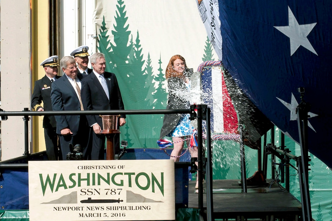 Elisabeth Mabus, daughter of Navy Secretary Ray Mabus, seconf from right, smashes a bottle of sparkling wine across the bow of the Virginia-class submarine Washington in Newport News, Va., March 5, 2016, to christen the submarine named for the Evergreen State. Photo courtesy of John Whalen, Huntington Ingalls Industries