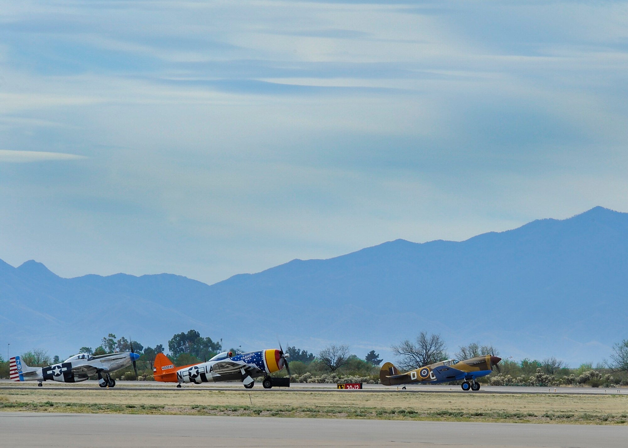 Two P-51 Mustangs and a P-47 Thunderbolt, center, taxi down the flightline during the 2016 Heritage Flight Training and Certification Course at Davis-Monthan Air Force Base, Ariz., March 6, 2016. The HFTCC provides civilian and military pilots the opportunity to practice flying in formation together in preparation for future air shows. (U.S. Air Force photo by Airman 1st Class Ashley N. Steffen/Released)