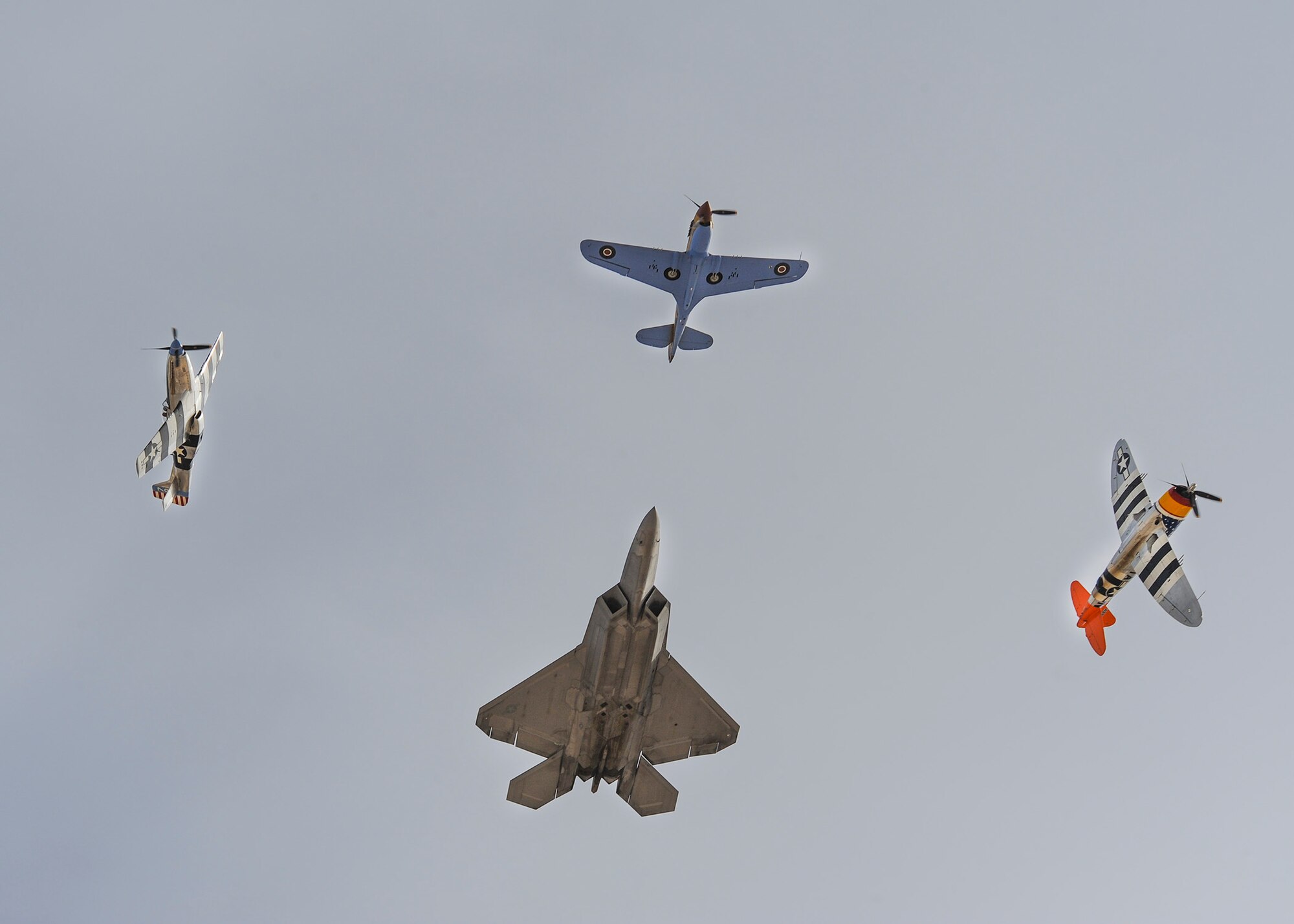 Two P-51 Mustangs, a P-47 Thunderbolt and a U.S. Air Force F-22 Raptor fly in formation during the 2016 Heritage Flight Training and Certification Course at Davis-Monthan Air Force Base, Ariz., March 6, 2016. During the course, aircrews practice ground and flight training to enable civilian pilots of historic military aircraft and U.S. Air Force pilots of current fighter aircraft to fly safely in formations together. (U.S. Air Force photo by Airman 1st Class Ashley N. Steffen/Released)