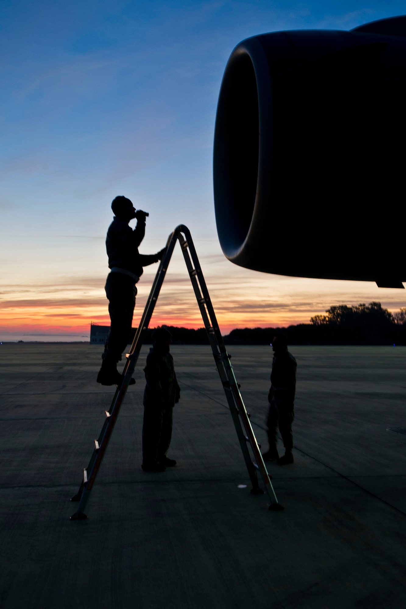 Staff Sgt. Matt Duvall, 446th Aircraft Maintenance Squadron aerospace propulsion specialist, inspects the engines of a C-17 Globemaster III during sunrise the morning of February 24th, 2016, at Naval Station Rota, Spain. During the annual tour, the Reservists repaired five damaged engine fan blades. (U.S. Air Force Reserve photo by Staff Sgt. Madelyn McCullough)