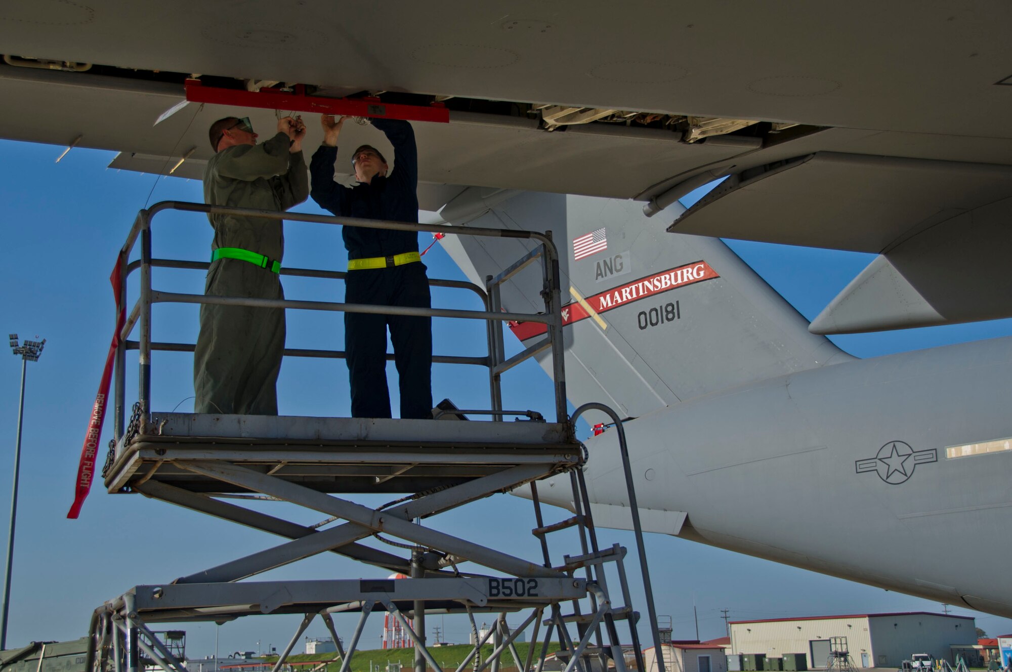 Tech. Sgt. Dave Wilde (left), 446th Aircraft Maintenance Squadron hydraulics technician, install an aileron surface lock on a C-17 Globemaster III February 23, 2016 at Naval Station Rota, Spain. These locks need to be installed to keep the control surfaces from moving during maintenance of certain hydraulic components. (U.S. Air Force Reserve photo by Staff Sgt. Madelyn McCullough)