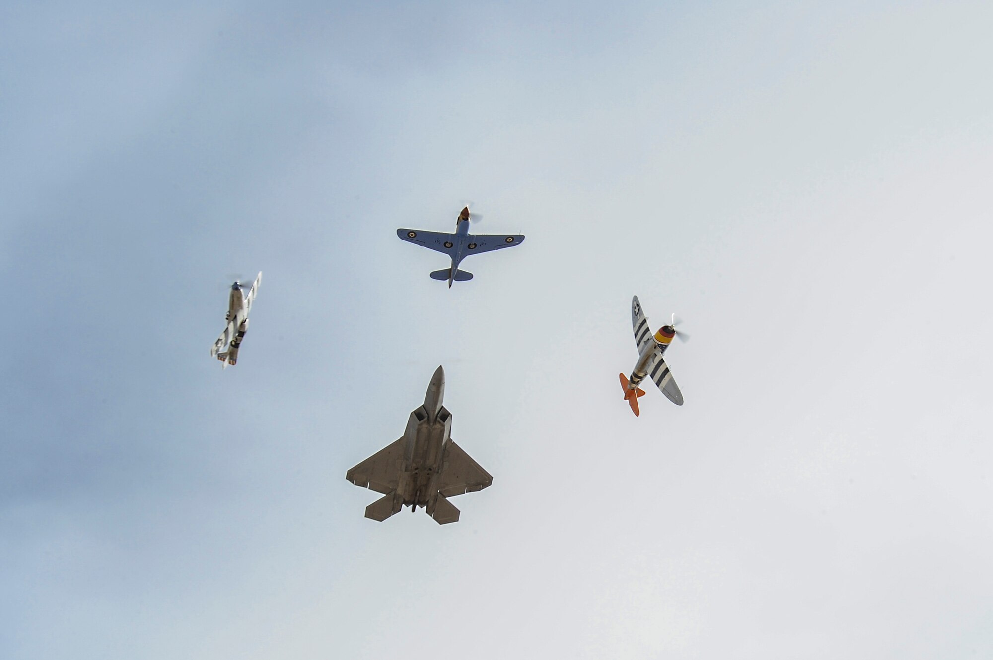 Two P-51 Mustangs, a P-47 Thunderbolt and a U.S. Air Force F-22 Raptor fly in formation during the 2016 Heritage Flight Training and Certification Course at Davis-Monthan Air Force Base, Ariz., March 6, 2016. During the course, aircrews practice ground and flight training to enable civilian pilots of historic military aircraft and U.S. Air Force pilots of current fighter aircraft to fly safely in formations together. (U.S. Air Force photo by Airman 1st Class Mya M. Crosby/Released)
