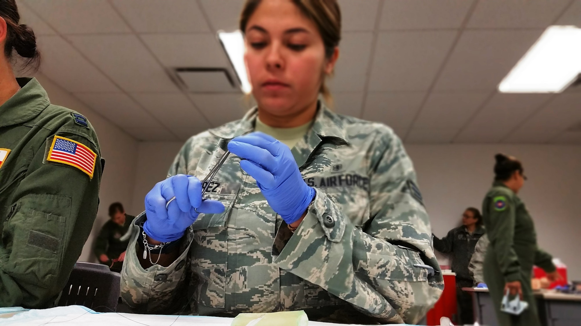Senior Airman Vania Perez, 433rd AES aeromedical evacuation technician, practices inserting surgical thread into forceps March 4, 2016 at Joint Base San Antonio-Lackland, Texas.  Airmen spent part of the super UTA learning new skills in a variety of medical classes designed to save lives. (U.S. Air Force photo by Tech. Sgt. Carlos J. Trevino)