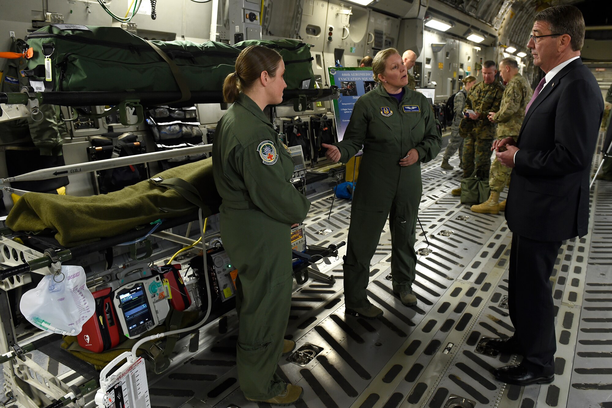 Maj. Beverly Davidson (center), 446th Aeromedical Evacuation Squadron flight nurse, and Tech. Sgt. Kassy Kvam (left), 446th AES technician, brief Defense Secretary Ash Carter about aeromedical evacuation procedures March 4, 2016 at Joint Base Lewis-McChord, Wash. Carter spoke of the total force concept here at JBLM and this was just one demonstration that highlighted that.  (U.S. Air Force photo/Tech. Sgt. Tim Chacon) 