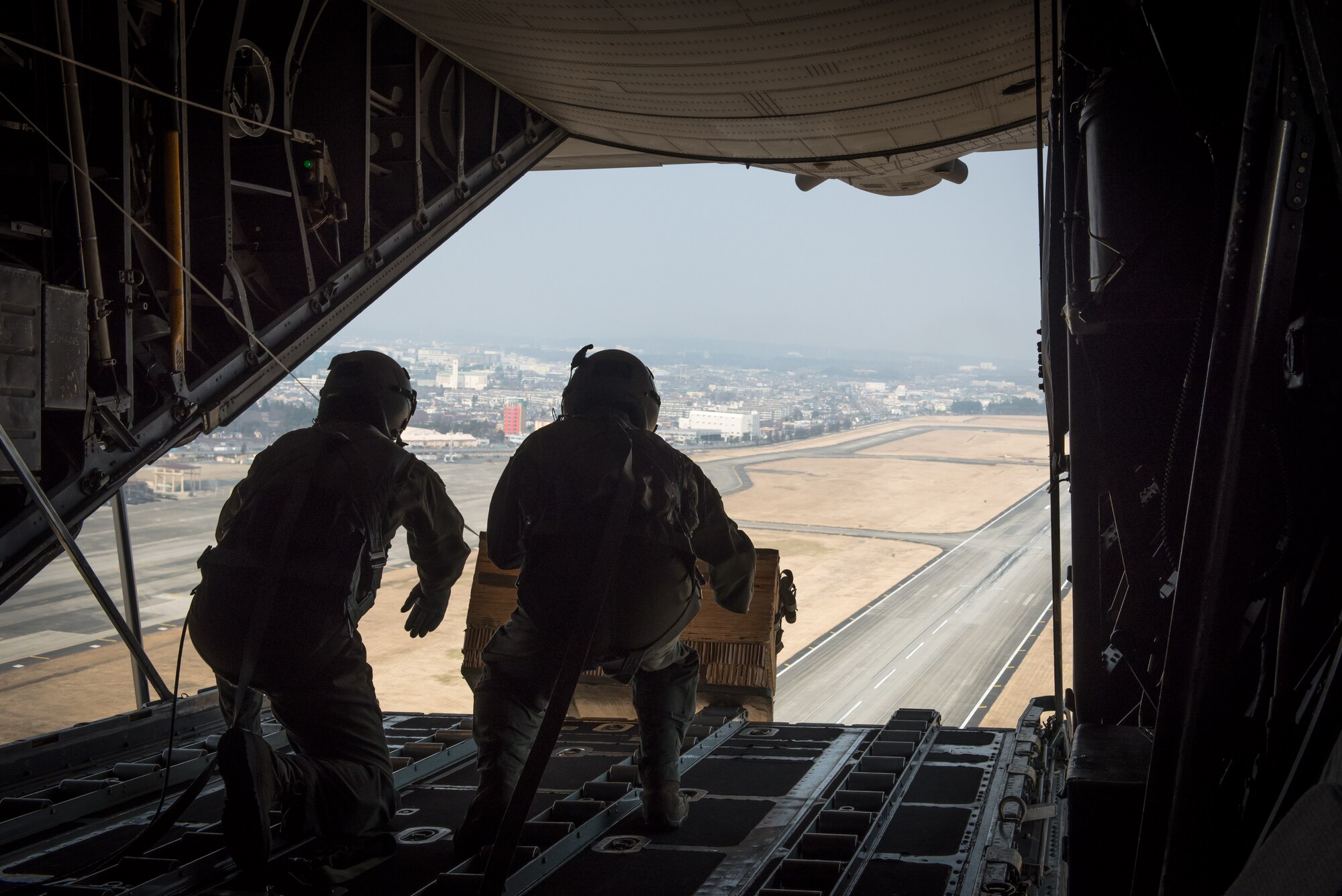 Lt. Gen. John Dolan, U.S. Forces, Japan and 5th Air Force commander, and Master Sgt. Richard LaFrance, 36th Airlift Squadron loadmaster, push a simulated low-cost low-altitude bundle out the back of a C-130 Hercules over Yokota Air Base, Japan, March 4, 2016. This was Dolan’s first time flying with the 36th Airlift Squadron as they conduct their training missions to remain proficient to support any contingency.  (U.S. Air Force photo by Staff Sgt. Michael Smith/Released)   