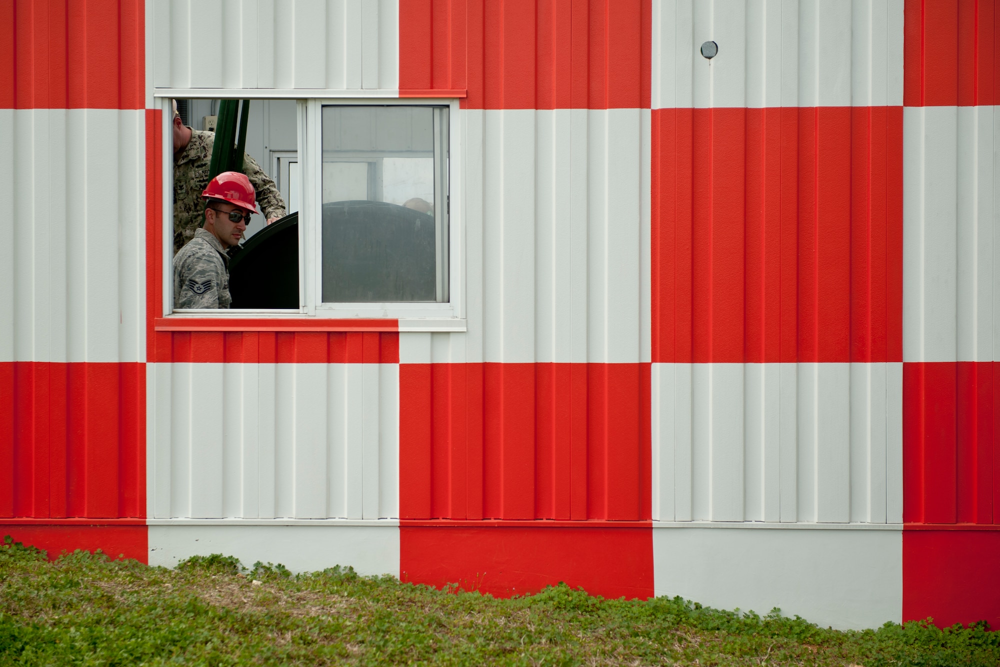 U.S. Air Force Staff Sgt. Michael Rodriguez, 18th Civil Engineer Squadron electrical power production craftsman, supervises a BAK-12 aircraft arresting system installation in a barrier shack Feb. 29, 2016, at Kadena Air Base, Japan. Rodriguez and members of U.S. Naval Mobile Construction Battalion 3 overhauled the barrier system, which requires replacement every ten years. (U.S. Air Force photo by Senior Airman Peter Reft)