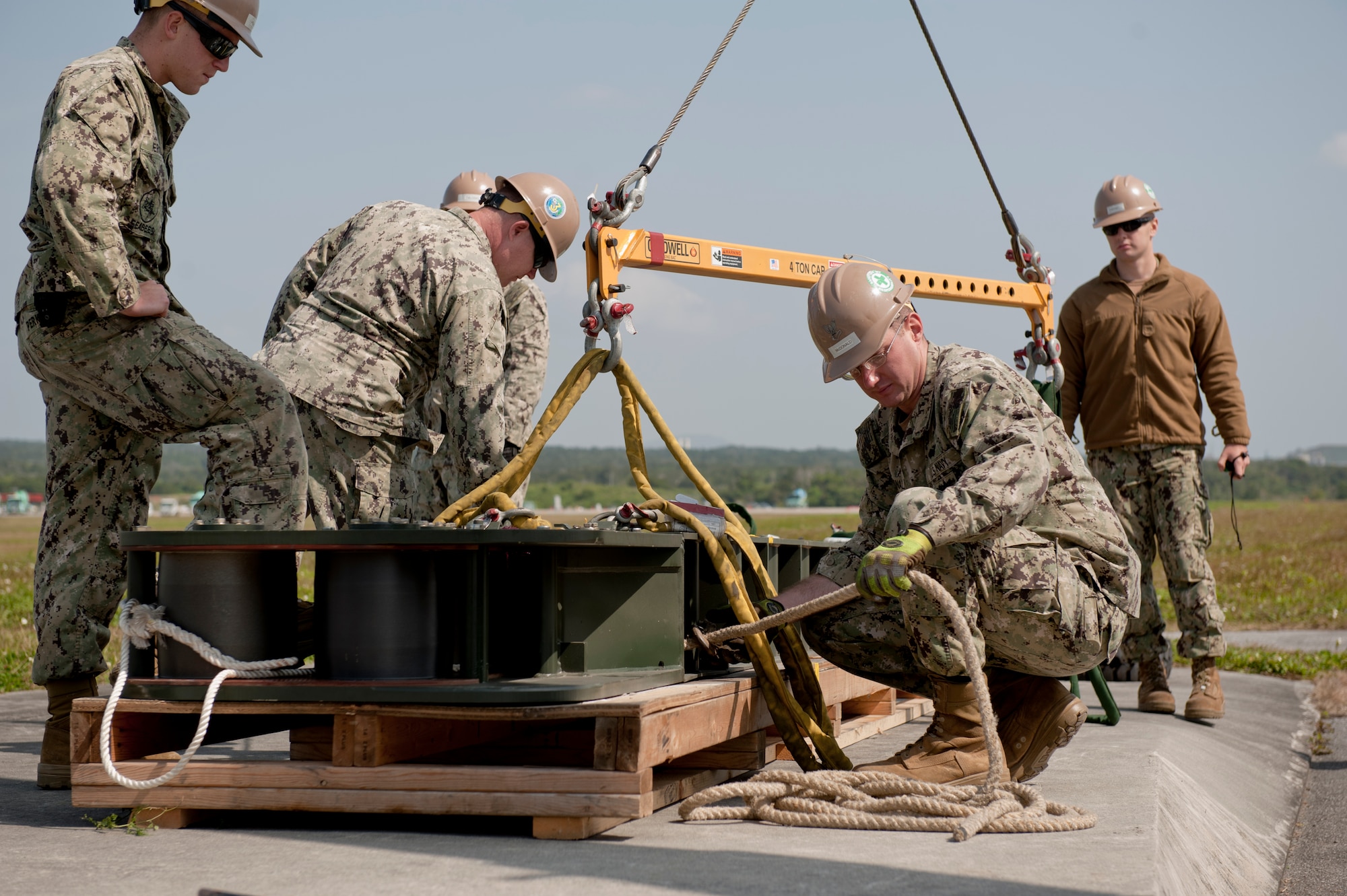 U.S. Navy Equipment Operator 2nd Class Joshua McDonald, Naval Mobile Construction Battalion 3 Seabees construction man, secures a tug line to a fairlead beam on the flight line Feb. 29, 2016, at Kadena Air Base, Japan. Seabees and barrier maintenance Airmen of the 18th Civil Engineer squadron overhauled the aircraft arresting barrier system as part of scheduled 10 year maintenance. (U.S. Air Force photo by Senior Airman Peter Reft)