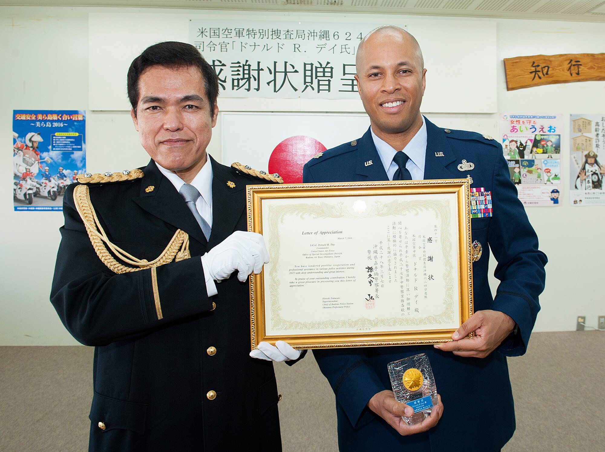 U.S. Air Force Lt. Col. Donald Day, Detachment 624th Air Force Office of Special Investigations commander, receives a letter of appreciation from Hiroshi Fukuzato, chief of Kadena Police Station, at Kadena Police Station, March 7, 2016, at Okinawa, Japan. Day and his staff supported Kadena Police Station on criminal and counterintelligence investigations this past year. (U.S. Air Force photo by Naoto Anazawa)
