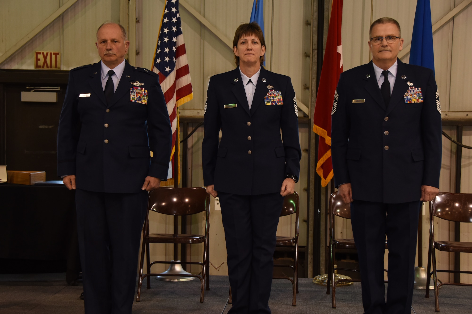 Brig. Gen. Matthew P. Jamison, Assistant Adjutant General for South Dakota Air National Guard, and retiring State Command Chief Master Sgt. James Welch stand at attention with incoming State Command Chief Master Sgt. Jean Gacke at Joe Foss Field, S.D. March 5, 2016. A ceremony was held to recognize the change of responsibility for these individuals. (U.S. Air National Guard photo by Staff Sgt. Luke Olson/Released)