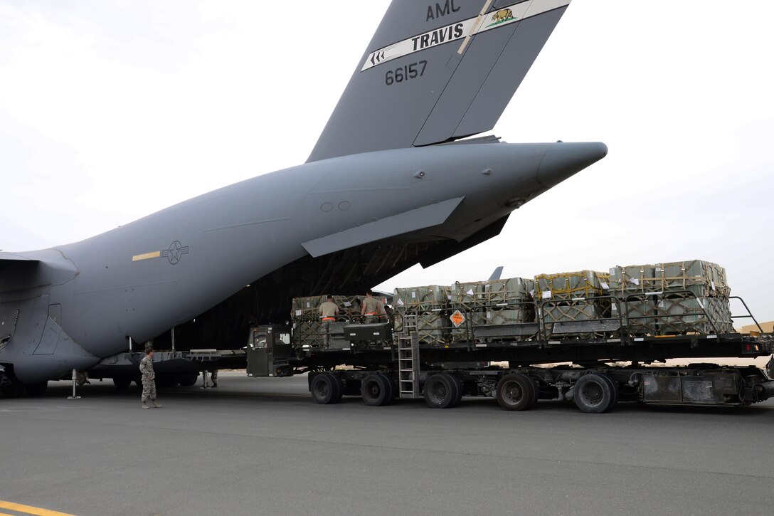 Airmen from the 8th Expeditionary Air Mobility Squadron Ramp Services team load munitions onto a C-17 Globemaster III from Travis Air Force Base, Calif., at Al Udeid Air Base, Qatar Feb. 26 in support of Operation Inherent Resolve. In February the team loaded more than 3,500 tons of cargo onto U.S. aircraft. (U.S. Air Force photo by Tech. Sgt. James Hodgman/Released) 