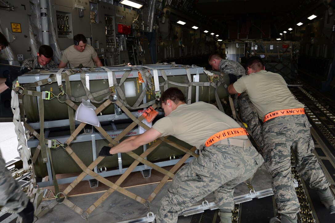 Airmen from the 8th Expeditionary Air Mobility Squadron Ramp Services team load munitions onto a C-17 Globemaster III from Travis Air Force Base, Calif., at Al Udeid Air Base, Qatar Feb. 26 in support of Operation Inherent Resolve. In February the team loaded more than 3,500 tons of cargo onto U.S. aircraft. Photo altered for security purposes. (U.S. Air Force photo by Tech. Sgt. James Hodgman/Released) 