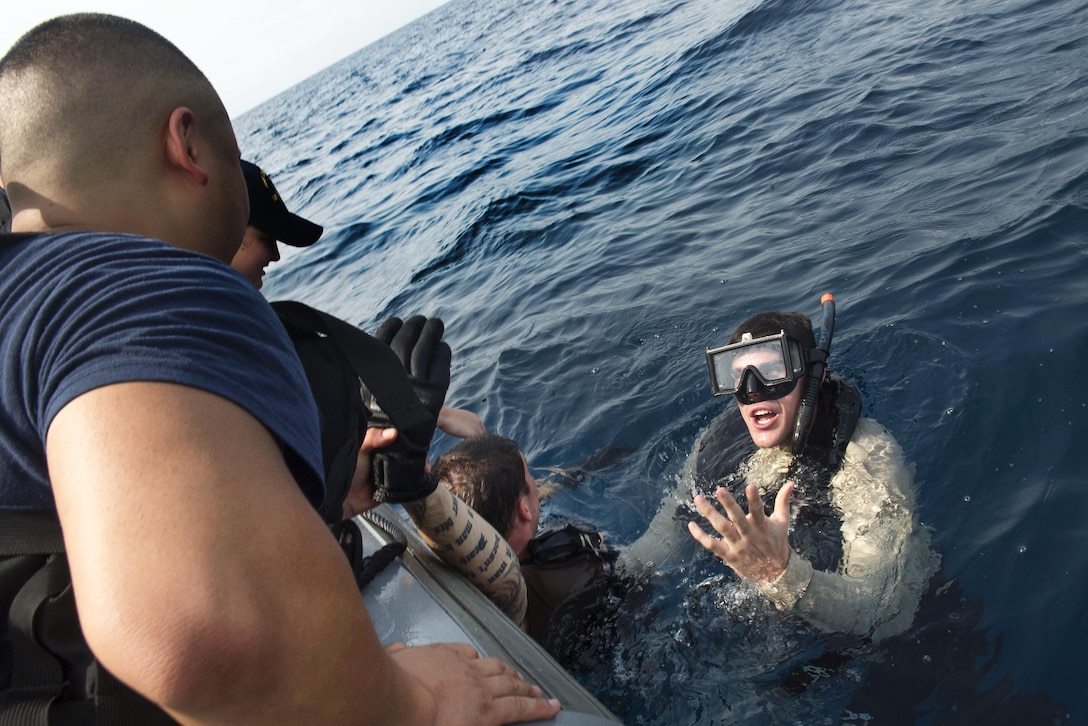 Navy Petty Officer 2nd Class Deon Farmer, right, and Navy Seaman Dylan Smith-Boccadoro conduct search and rescue training in the Atlantic Ocean, March 3, 2016. Farmer is a boatswain's mate, search-and-rescue swimmer and Smith-Boccadoro is a ship's serviceman assigned to the USNS Spearhead. Navy photo by Petty Officer 1st Class Amanda Dunford