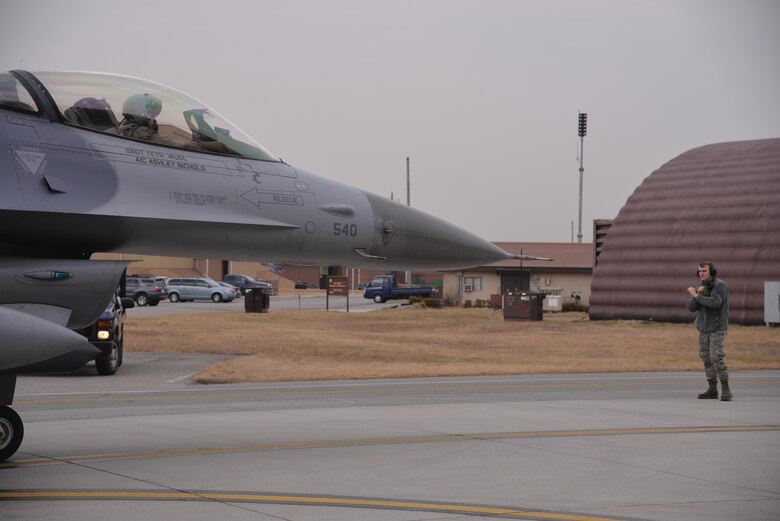Airman 1st Class Nathan Knutson, 36th Aircraft Maintenance Unit crew chief, marshals a jet to a stop March 7, 2016, at Osan Air Base, Republic of Korea. Members of the 36th AMU generated multiple aircraft throughout the day in preparation for combat readiness exercise Beverly Midnight 16-01. (U.S. Air Force photo by Staff Sgt. Benjamin Sutton/Released)  