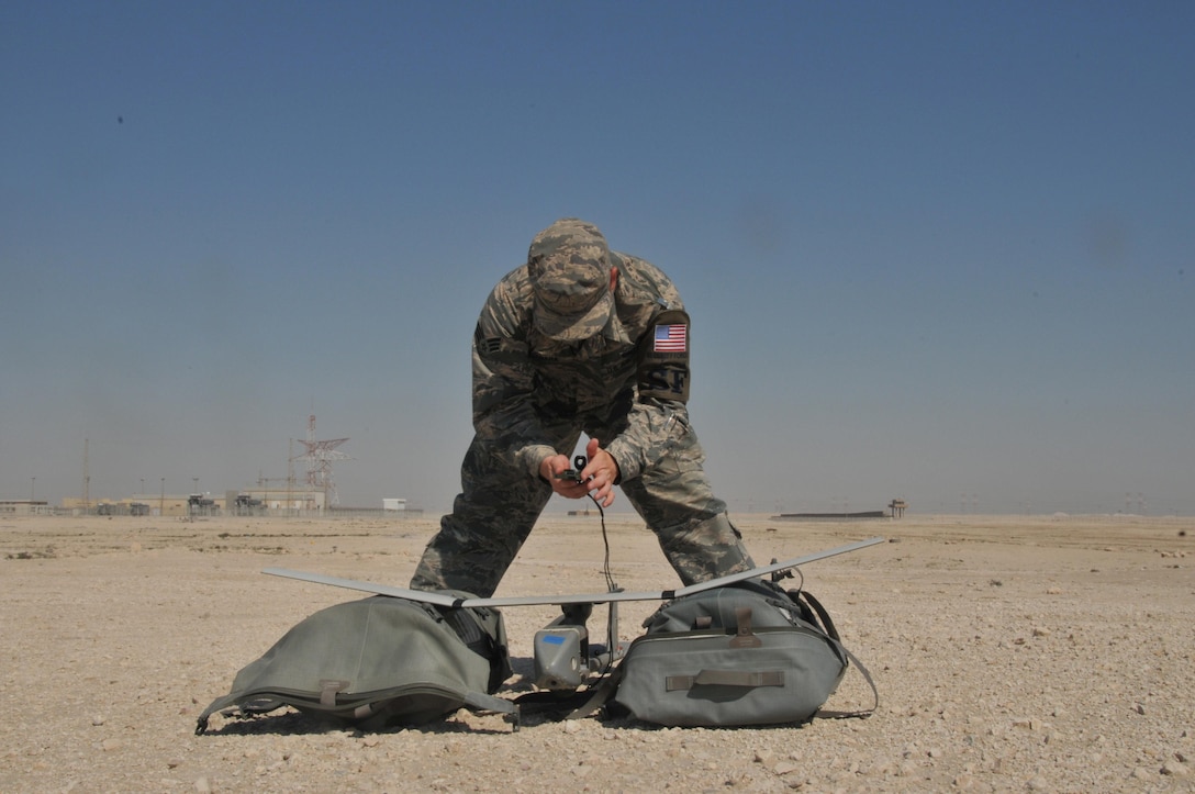 Senior Airman James McGaha, 379th Expeditionary Security Force Squadron patrolman, prepares the Raven B Digital Data Link drone, a small unmanned aircraft or drone, for flight Feb. 19 at Al Udeid Air Base, Qatar. McGaha checks the drone’s wires and connections to ensure components are operational before flight. (U.S. Air Force photo by Tech. Sgt. Terrica Y. Jones/Released) 