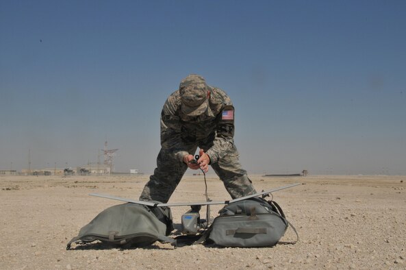 Senior Airman James McGaha, a 379th Expeditionary Security Force Squadron patrolman, prepares the Raven B Digital Data Link drone for flight Feb. 19, 2016, at Al Udeid Air Base, Qatar. McGaha checks the drone’s wires and connections to ensure components are operational before flight. (U.S. Air Force photo/Tech. Sgt. Terrica Y. Jones)