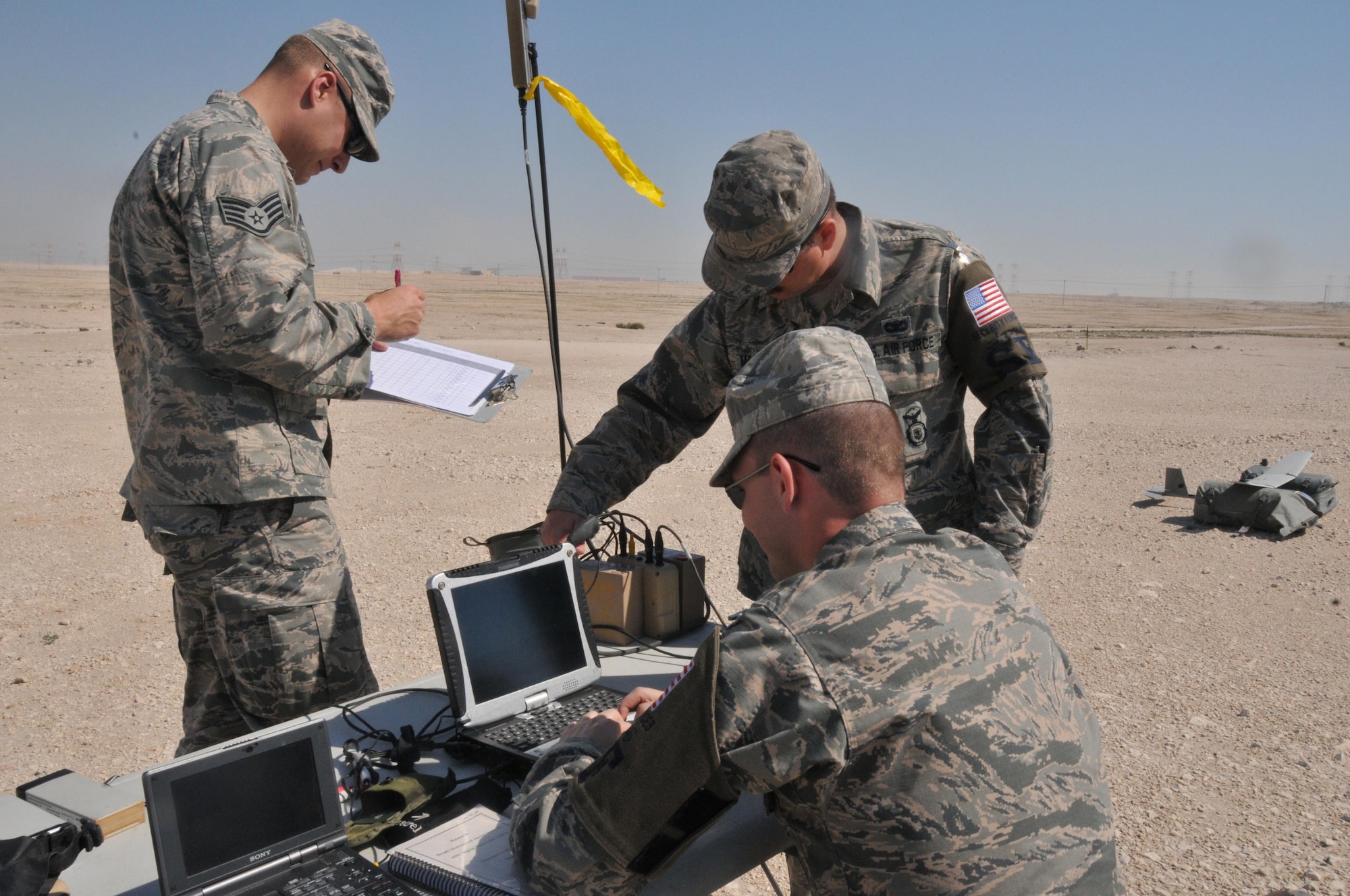 Senior Airman James McGaha (left), Airman 1st Class Chris Dial (middle) and Staff Sgt. Christopher Pfeiffer (right), 379th Expeditionary Security Force Squadron patrolmen, set up for a Raven B Digital Data Link drone, small unmanned aircraft or drone, flight Feb. 19 at Al Udeid Air Base, Qatar. Depending on the weather, the drone can fly between 60-90 minutes in duration. (U.S. Air Force photo by Tech. Sgt. Terrica Y. Jones/Released) 