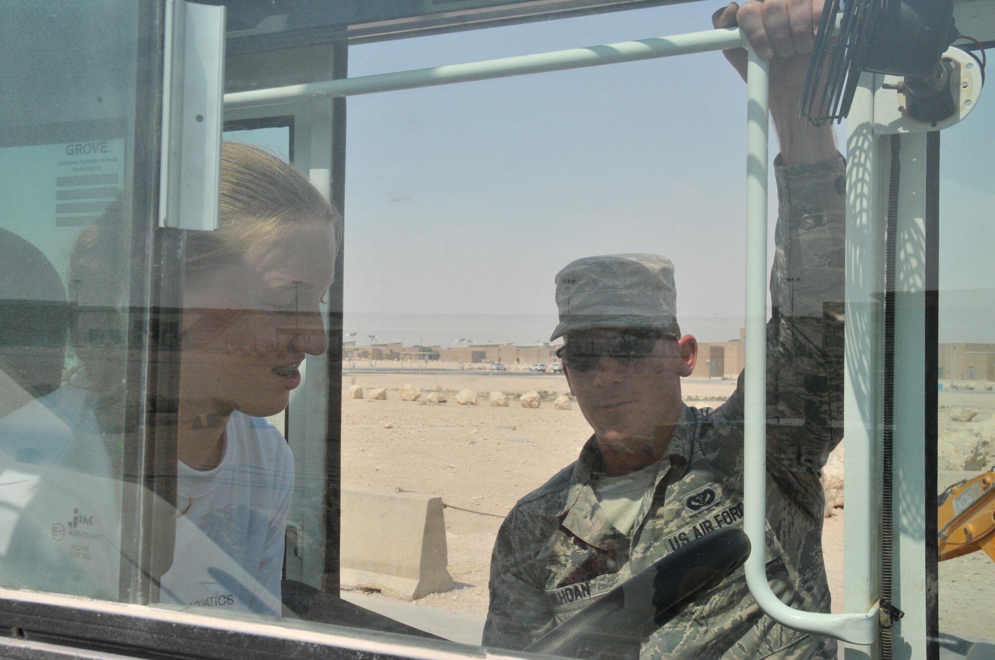 Senior Airman Christian Milhoan, 379th Expeditionary Civil Engineer Squadron heavy equipment operator, talks with eighth graders from the American School of Doha, Mar. 3 at Al Udeid Air Base, Qatar. Milhoan talks with groups of students as they climb into the equipment to see how everything works from the operator’s perspective. (U.S. Air Force photo by Tech. Sgt. Terrica Y. Jones)