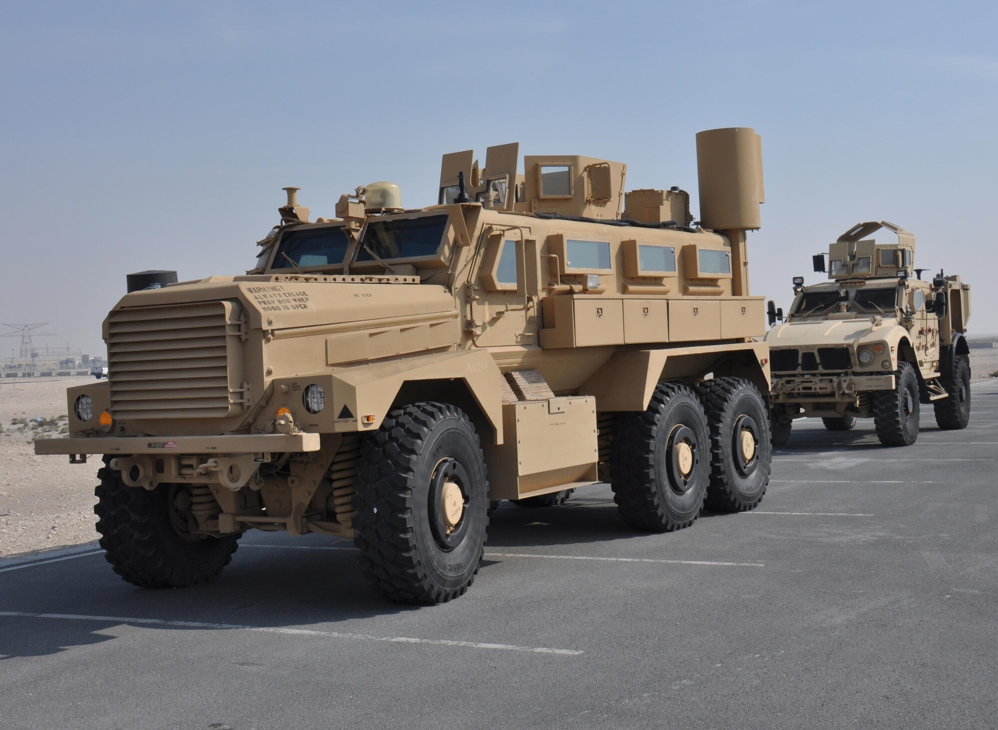 Two mine resistant ambush protectant vehicles are on display in the Blatchford Preston Complex gym parking lot during a visit by approximately 200 American School of Doha students at Al Udeid Air Base, Qatar March 3. The vehicles were part of a static vehicle display, which also featured a fire truck and a crane. During the visit, students watched a military working dog demonstration, toured a KC-135 Stratotanker and met with U.S. Airmen from a variety of specialties. (U.S. Air Force photo by Tech. Sgt. James Hodgman/Released)