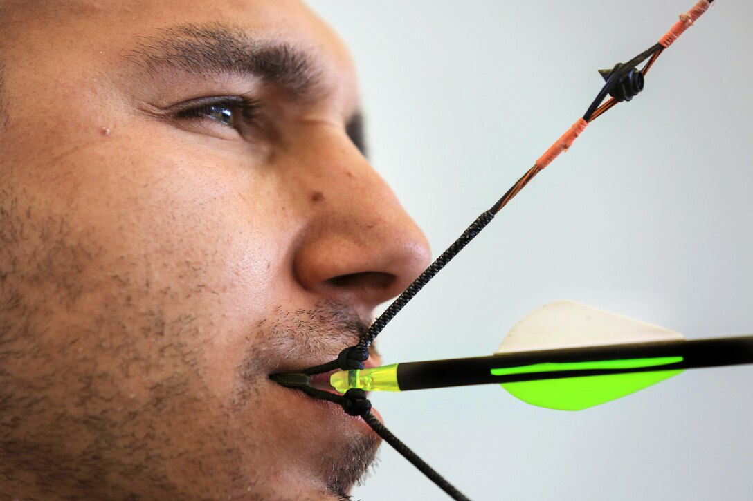 Retired Army Sgt. Robbie Gaupp draws his bow using his mouth during archery training during the Army Trials on Fort Bliss, Texas, March 1, 2016. Army photo by Pfc. Ian Ryan