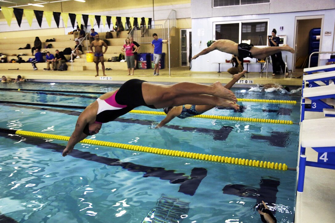 Active duty soldiers and veterans dive off the starting block into the pool to practice swimming techniques during the Army Trials at the Aquatics Training Center on Fort Bliss, Texas, March 1, 2016. Army photo by Spc. Adasia Ortiz