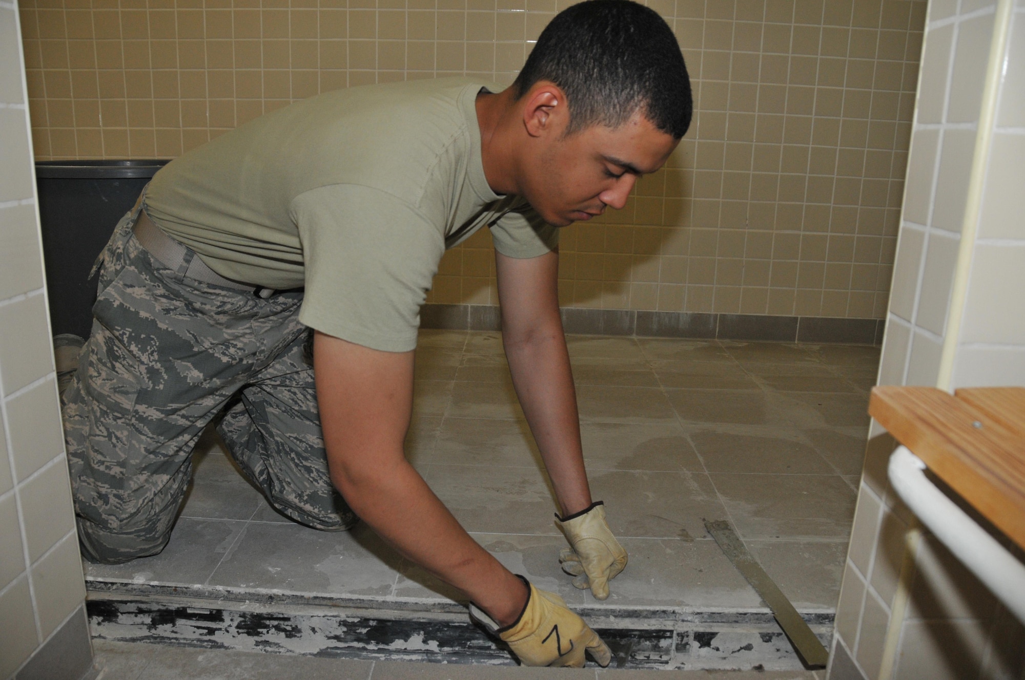 Senior Airman Martin Dumas, 379th Expeditionary Civil Engineer Squadron water and fuel systems maintainer, cleans calcium build up in a latrine unit or Cadillac shower Mar. 1 at Al Udeid Air Base, Qatar. The Cadillac Renovation Team cleans the shower trough and checks the pipelines for stoppages to remove any restrictions in the line. (U.S. Air Force photo by Tech. Sgt. Terrica Y. Jones)