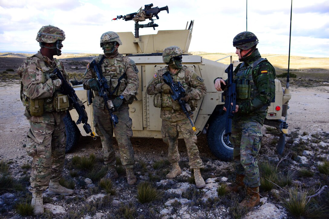 Army paratroopers and a Spanish army soldier, right, talk before participating in an air assault mission during Exercise Sky Soldier 16 at the Chinchilla training area in Spain, Feb. 25, 2016. Army photo by Elena Baladelli