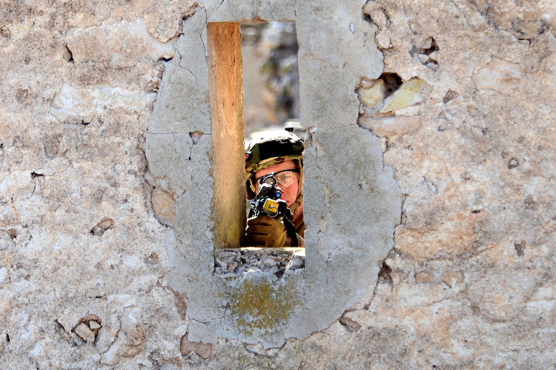 A U.S. paratrooper prepares to return fire from a window during Exercise Sky Soldier 16 at Chinchilla training area in Albacete, Spain, Feb. 29, 2016. The paratrooper is assigned to the 173rd Airborne Brigade. Army photo by Staff Sgt. Opal Vaughn