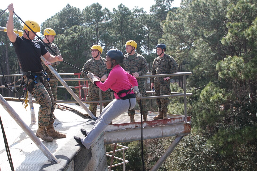 An educator leans back into their harness to begin their scale down a fifty foot rappel tower March 3, 2016, about Marine Corps Recruit Depot Parris Island, S.C. The rappel tower is a part of the Marine recruit experience to earn the title Marine. Educators from Recruiting Stations Atlanta and Columbia have embarked on a three-day workshop to learn more about the Marine Corps so when their students inquire about the military they are well informed. (Official Marine Corps photo by Cpl. Diamond N. Peden/Released)